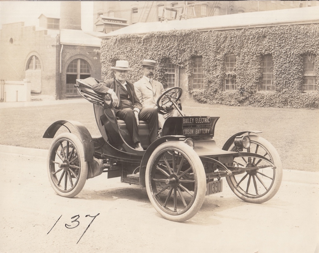Thomas Edison seated in a Bailey Electric automobile alongside Col. E.M.E. Bailey, circa 1910s.